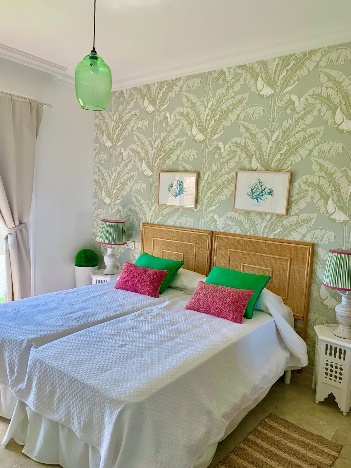 Bright bedroom with decorative wallpaper in a duplex apartment in San Roque Club Sotogrande.