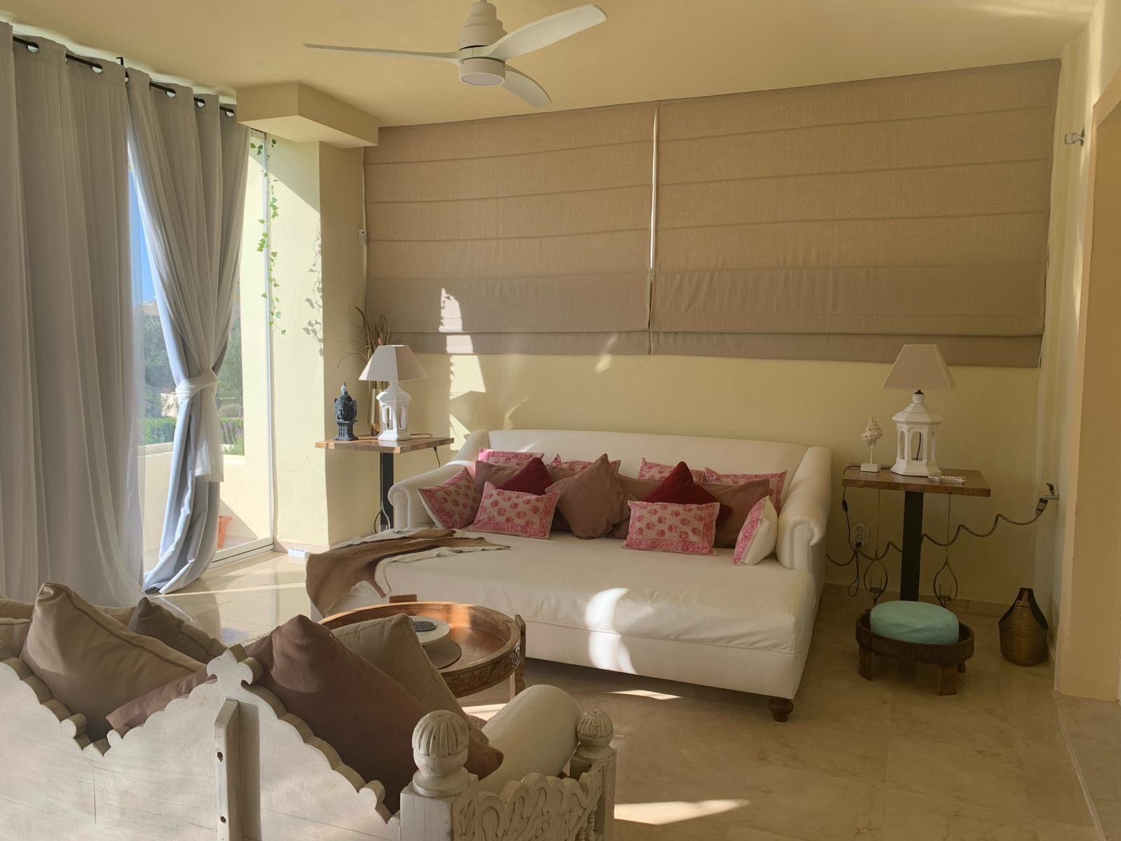 Bright living room with terrace and glass curtains in a furnished duplex apartment in San Roque Club Sotogrande.